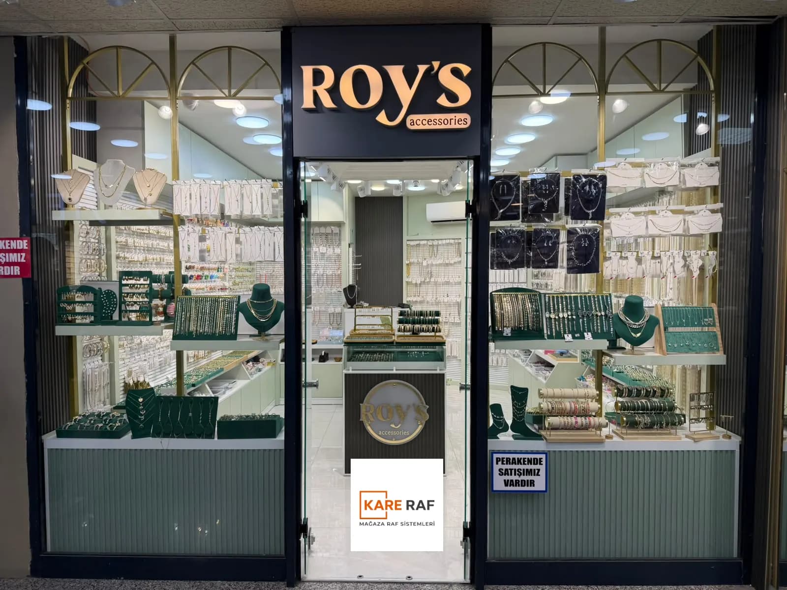 Roy's Accessories'in Tahtakale'deki cephesi: altın kemerli iki vitrin, ortada cam kapı ve logolu stand