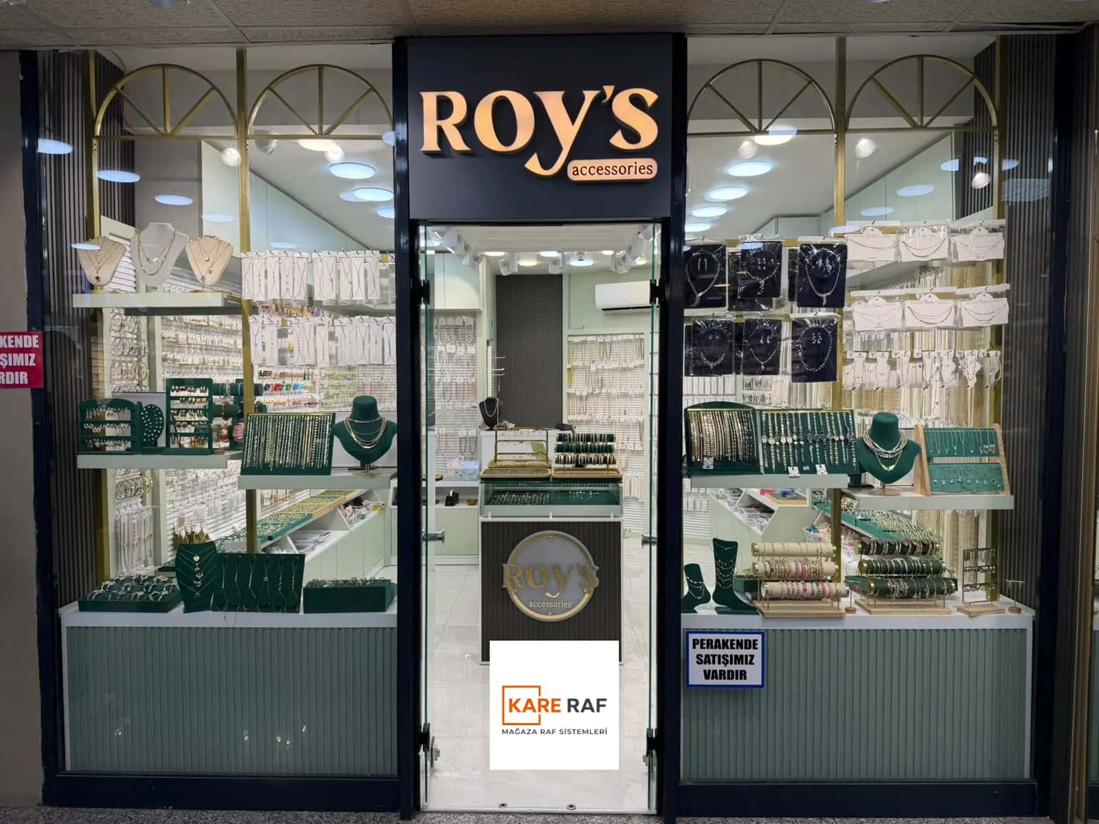 Roy's Accessories'in Tahtakale'deki cephesi: altın kemerli iki vitrin, ortada cam kapı ve logolu stand
